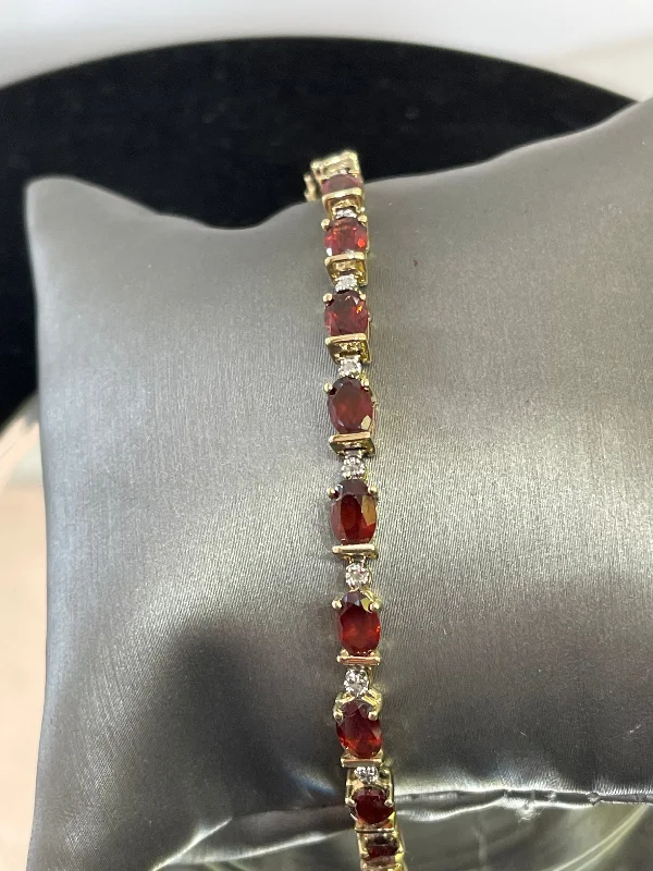 ladies-charm-diamond-bracelets-14KT Y/G Oval Garnet And Diamond Tennis Bracelet